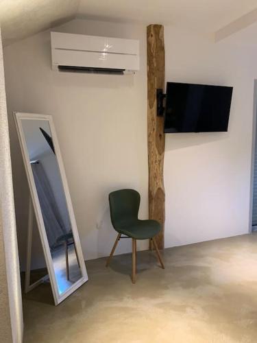 a room with a green chair and a mirror at Villa Falcone marinu ***** in Kamiesch