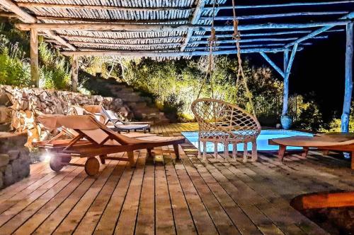 a patio with a swing and chairs and a pool at Villa Falcone marinu ***** in Kamiesch