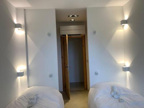a bedroom with two beds and two lights on the wall at Villa Falcone marinu ***** in Kamiesch