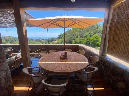 a table and chairs with an umbrella on a patio at Villa Falcone marinu ***** in Kamiesch