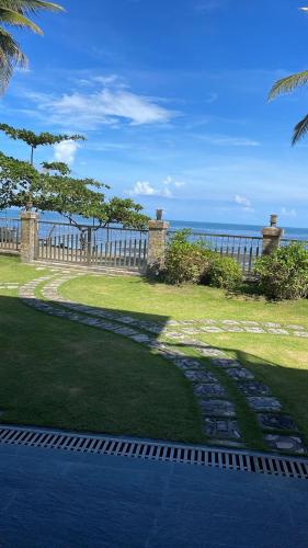 a walkway leading to the ocean with a fence at Nahas Beach Resort in Abung