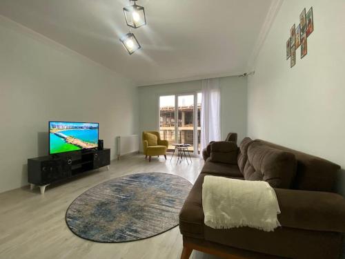 sala de estar con sofá y TV de pantalla plana en 2bedroom cozy apartment en Estambul