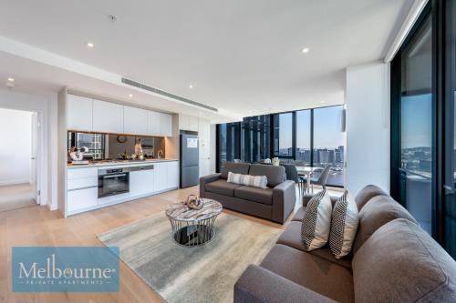 a living room with a couch and a table at Melbourne Private Apartments - Collins Wharf Waterfront, Docklands in Melbourne