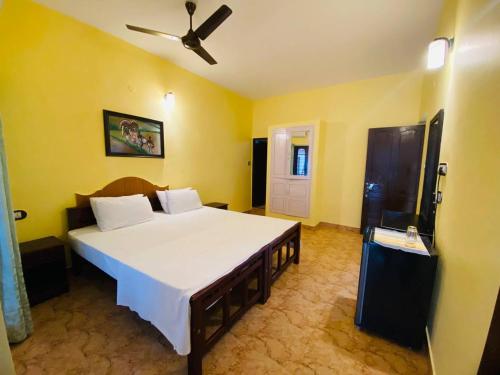 een slaapkamer met een groot bed en een plafondventilator bij Karma Beach Resort in Kovalam