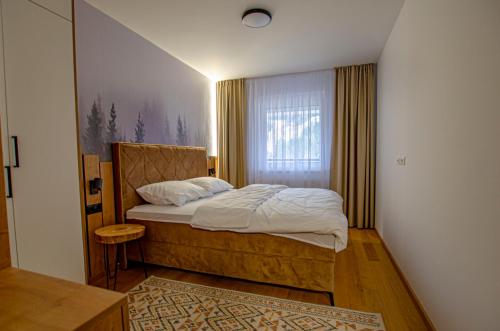 ein Schlafzimmer mit einem Bett und einem Fenster in der Unterkunft View Of The Top - Bjelašnica in Bjelašnica