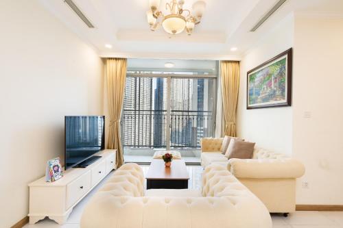 a living room with white furniture and a large window at Landmark Plus Luxury - Vinhomes Central Park in Ho Chi Minh City