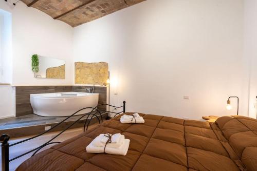 una camera con un grande letto e una vasca da bagno di L'Antica Voltina a Nettuno