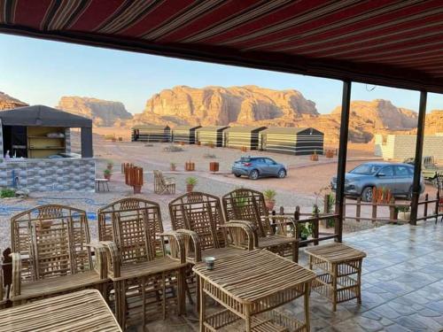 a patio with tables and chairs and a view of a parking lot at Blue Camel in Wadi Rum