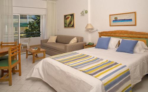 a bedroom with a bed and a living room at Ourabay Hotel Apartamento - Art & Holidays in Albufeira