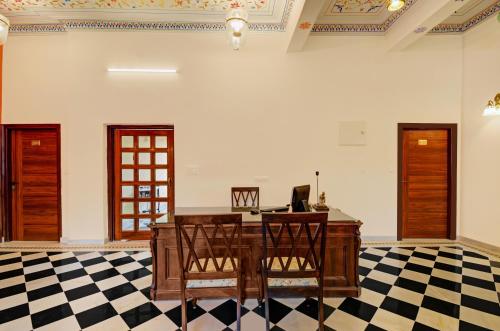 an office with a desk with a computer on a checkered floor at Hotel Karohi Villa in Udaipur
