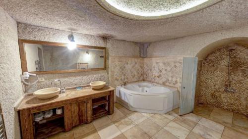 a bathroom with a tub and a toilet and a sink at Elegance Cave Suites & Restaurant in Goreme