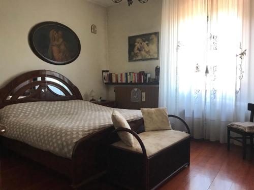 a bedroom with a bed and a chair and a window at Le Pergole in Trieste
