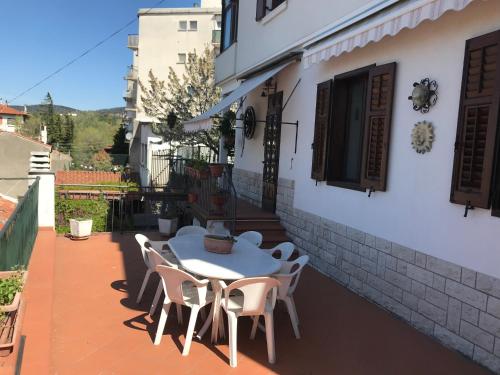 a white table and chairs on a patio at Le Pergole in Trieste