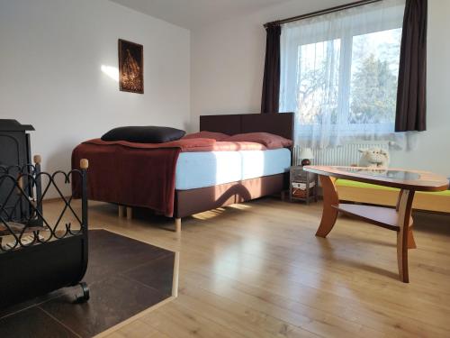 a bedroom with a bed and a table in it at Apartmán Bystré in Bystré