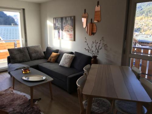 un salon avec un canapé et une table dans l'établissement Appart 3ch. entièrement rénové au coeur de Châtel, à Châtel