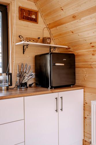 a kitchen with white cabinets and a black microwave at Hillside Kazbegi in Stepantsminda
