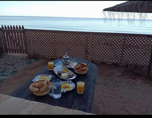 a picnic table with food and drinks on the beach at Dar diafa samira in Mirleft