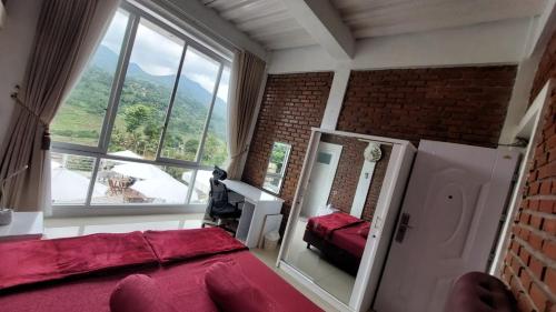um quarto com uma cama vermelha e uma grande janela em Teras Luhur Villa & Cafe dengan Pemandangan Gunung dan Pesawahan 