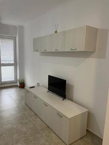 Habitación con escritorio y TV. en Garsoniera Tineretului, en Roşu