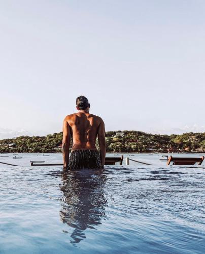 a man is sitting in a pool of water at Aurora Beach View in Nusa Lembongan