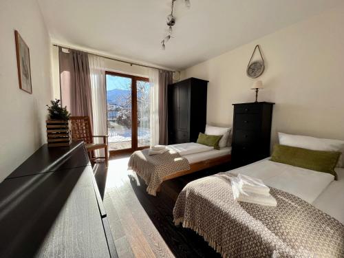 Sweet Alpen Home في غارميش - بارتنكيرشين: غرفة فندقية بسريرين ونافذة