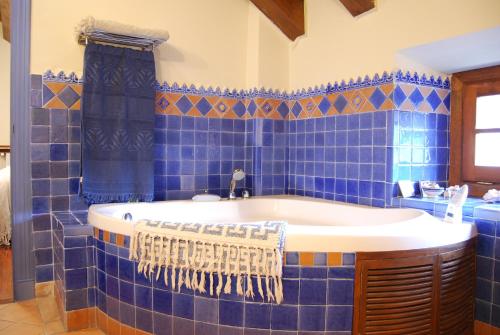 uma casa de banho com azulejos azuis e uma banheira. em Casa María Berna em Sarvisé