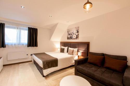 a hotel room with a bed and a couch at Velvet Studio Zoned Kopaonik in Kopaonik