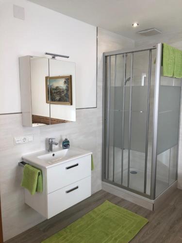 ein Badezimmer mit einem weißen Waschbecken und einer Dusche in der Unterkunft Gruberbauer Remsach in Bad Gastein