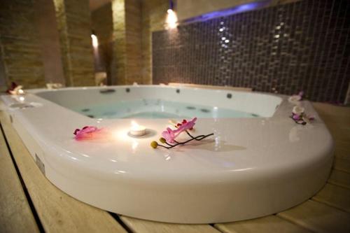 a bath tub with a candle and flowers on it at Velvet Studio Zoned Kopaonik in Kopaonik