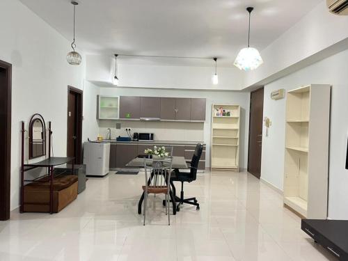 a living room with a table and a kitchen at Family House in Kuala Lumpur