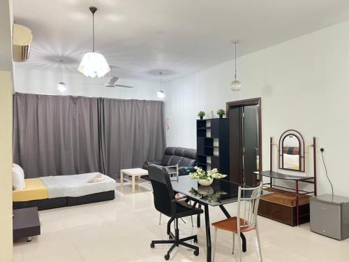 a living room with a bed and a table and chairs at Family House in Kuala Lumpur