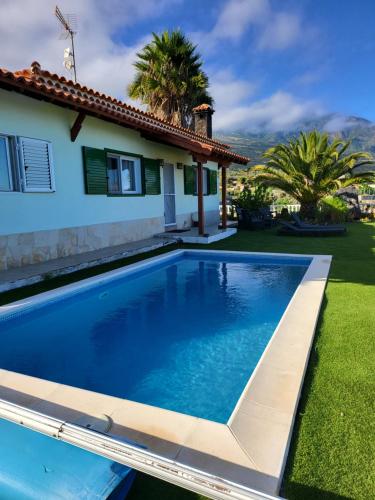 a swimming pool in front of a house at Seaview Chalet in Arafo