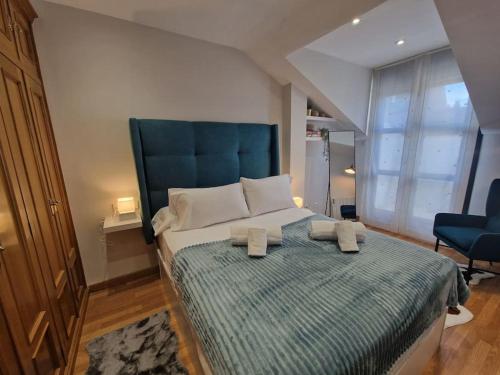 sypialnia z dużym łóżkiem z niebieskim zagłówkiem w obiekcie 614A Coqueto ático w mieście Oviedo