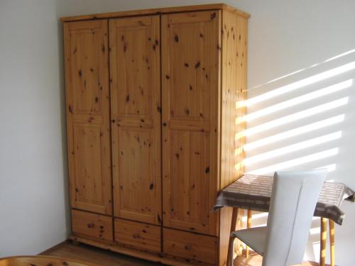 a wooden cabinet in a room with a chair at Haus Mundl in Tauplitz