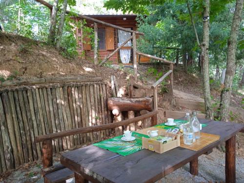 a wooden picnic table with a box and drinks on it at CHALET NEL BOSCO - TENUTA BOCCHINERI in Rogliano
