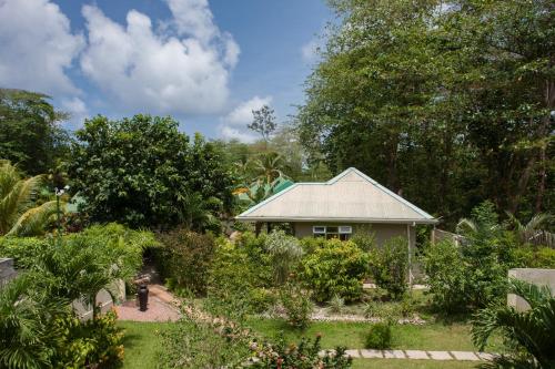 a garden in front of a small house at Casa De Leela Self Catering Guest House in La Digue