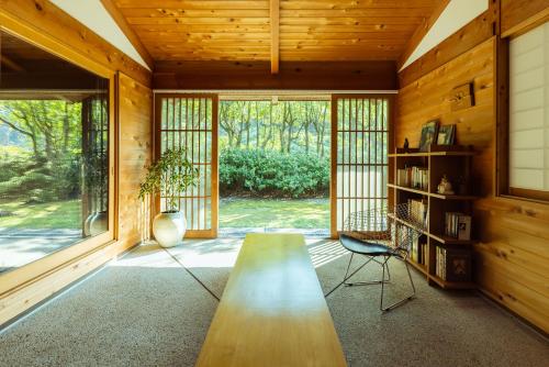 a room with a wooden table and a book shelf at 木木木木 KIGI MOKU MOKU in Sasebo