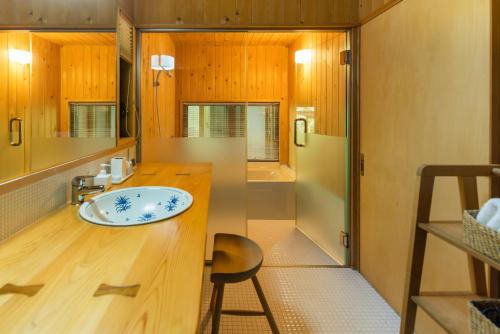 a bathroom with a sink and a shower and a stool at 木木木木 KIGI MOKU MOKU in Sasebo