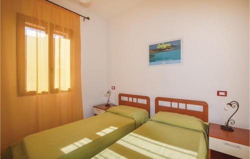 twee bedden in een kleine kamer met een raam bij Beautiful Apartment In Valledoria With Outdoor Swimming Pool And 2 Bedrooms in Valledoria