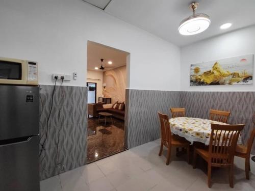 eine Küche und ein Esszimmer mit einem Tisch und Stühlen in der Unterkunft JC HOMESTAY PORT DICKSON in Port Dickson