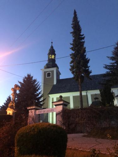 a church with a tower with a clock on it at Słoneczna Chata z Bali in Lądek-Zdrój
