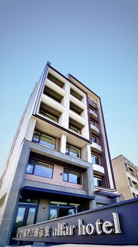 a tall building with a sign in front of it at alfar Hotel in Dayuan