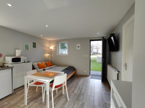 a bedroom with a bed and a table with chairs at Charmant studio á Autrans in Autrans
