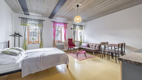 a bedroom with a bed and a living room at Apart Pension Zelený grunt in Dřínov