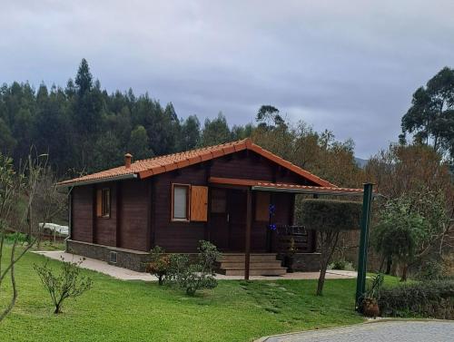 a small wooden house in a field of grass at Kombi House in Terras de Bouro