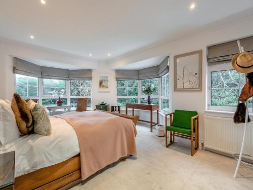 um quarto com uma cama, uma secretária e janelas em Windbrake House em Alverstoke