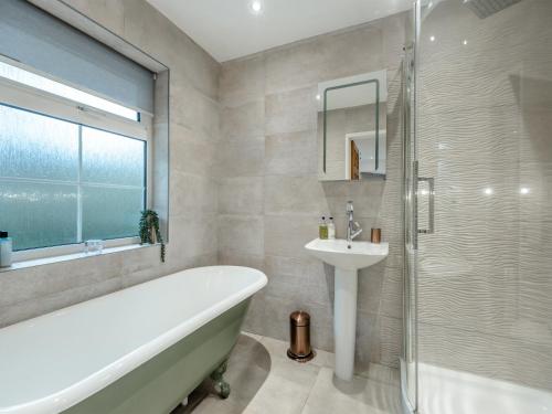uma casa de banho com uma banheira, um lavatório e um chuveiro em Windbrake House em Alverstoke