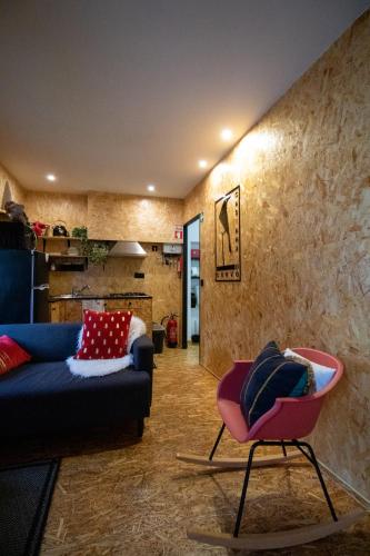 a living room with a blue couch and a pink chair at casinha do corvo in Fátima