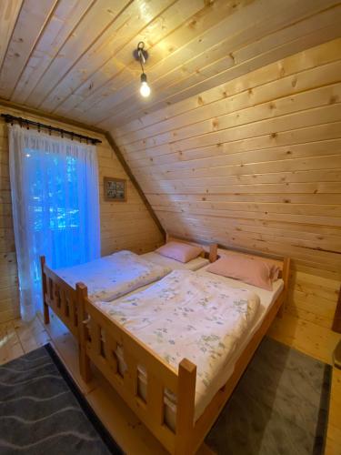 ヤホリナにあるEtno kuća ''Nada''の窓付きの木製の部屋の大型ベッド1台