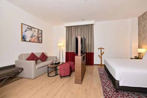 a hotel room with a bed and a couch at Comfort Hotel Jeddah King Road in Jeddah